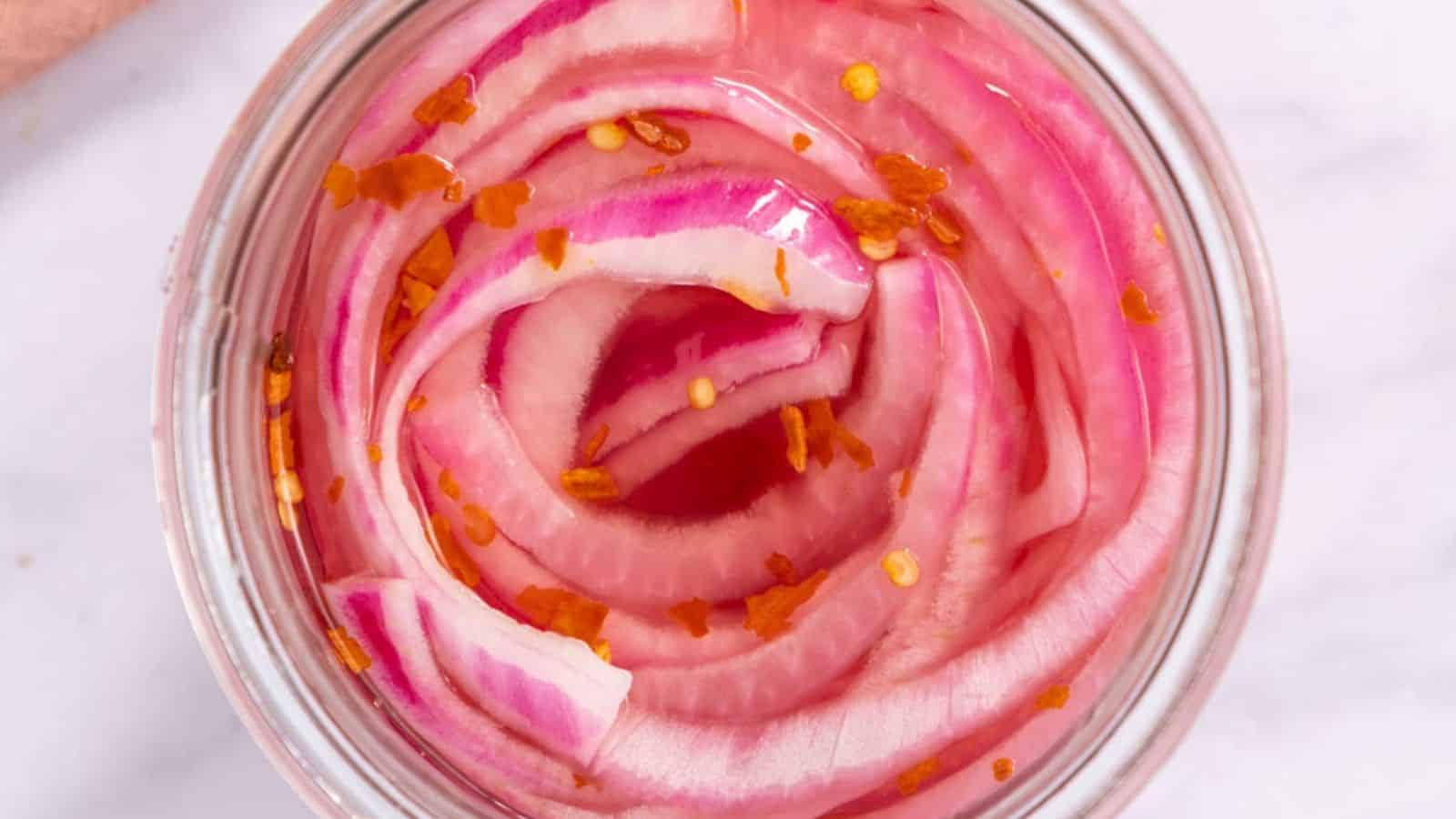 Top view of sweet and spicy pickled onions in a jar.