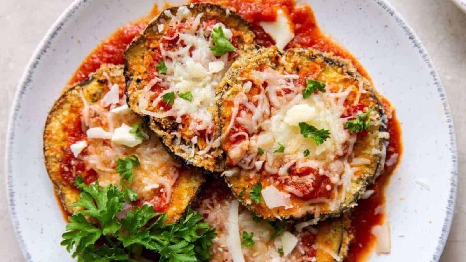 Air fryer eggplant parmesan in a plate with with basil leaves to add a pop of color and freshness.