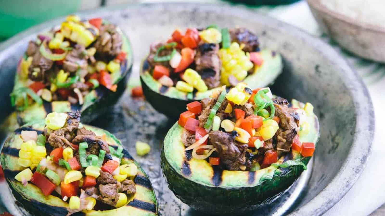 Close-up image of asian steak stuffed grilled avocados on a plate.