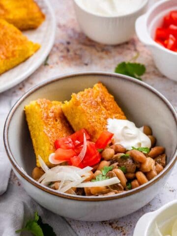 Beans and cornbread served together in a bowl.