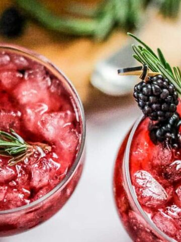 Top down view of two blackberry gin and tonics with crushed ice.