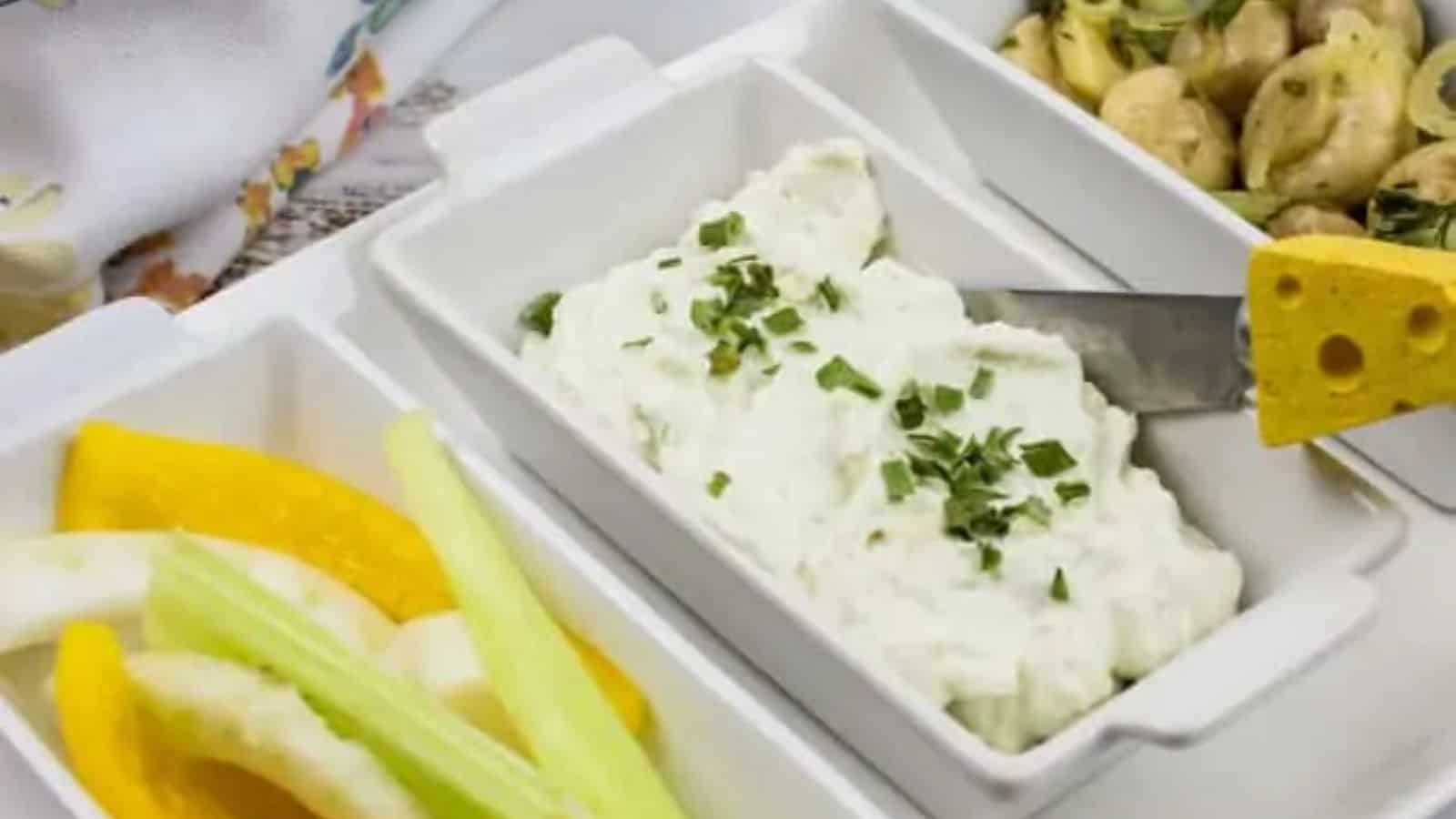 Close-up image of blue cheese dip in the middle of other dishes.