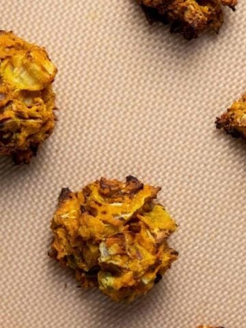 An overhead image of cooked cabbage fritters in a pan.