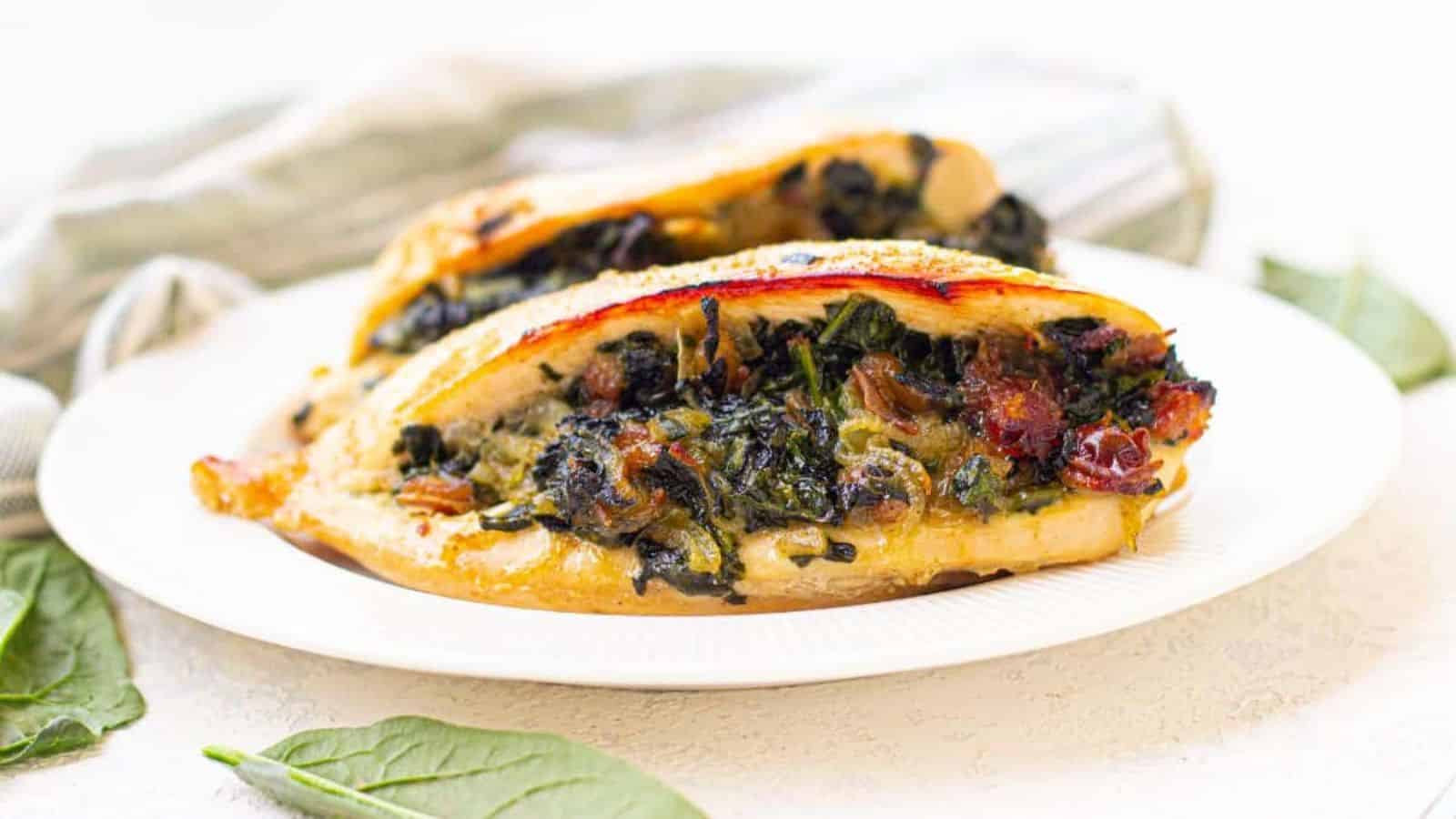 Chicken breasts stuffed with spinach and dates on a white plate.