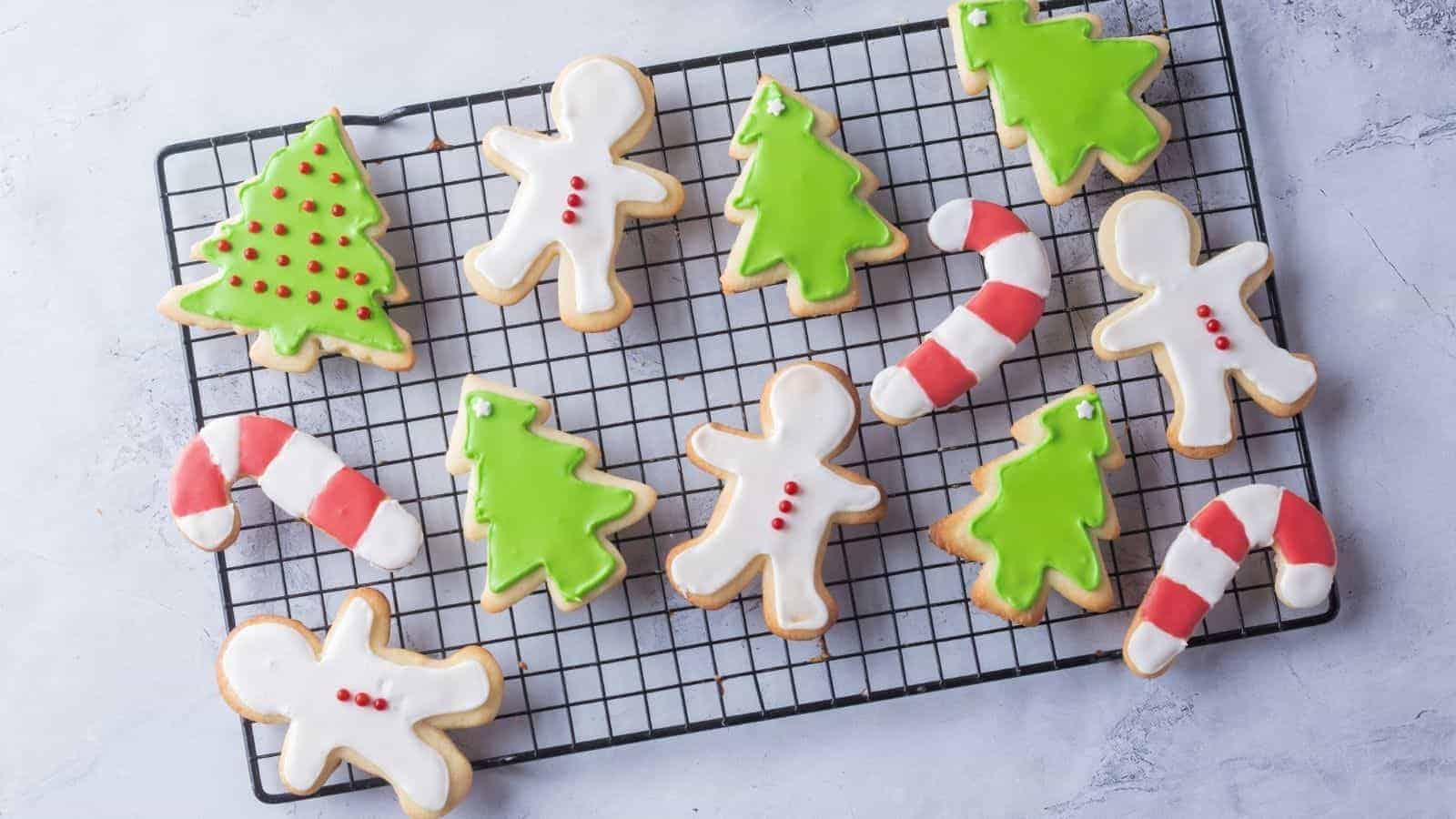 Overhead view of Christmas sugar cookies on a white plate, with cookies on the side as well.