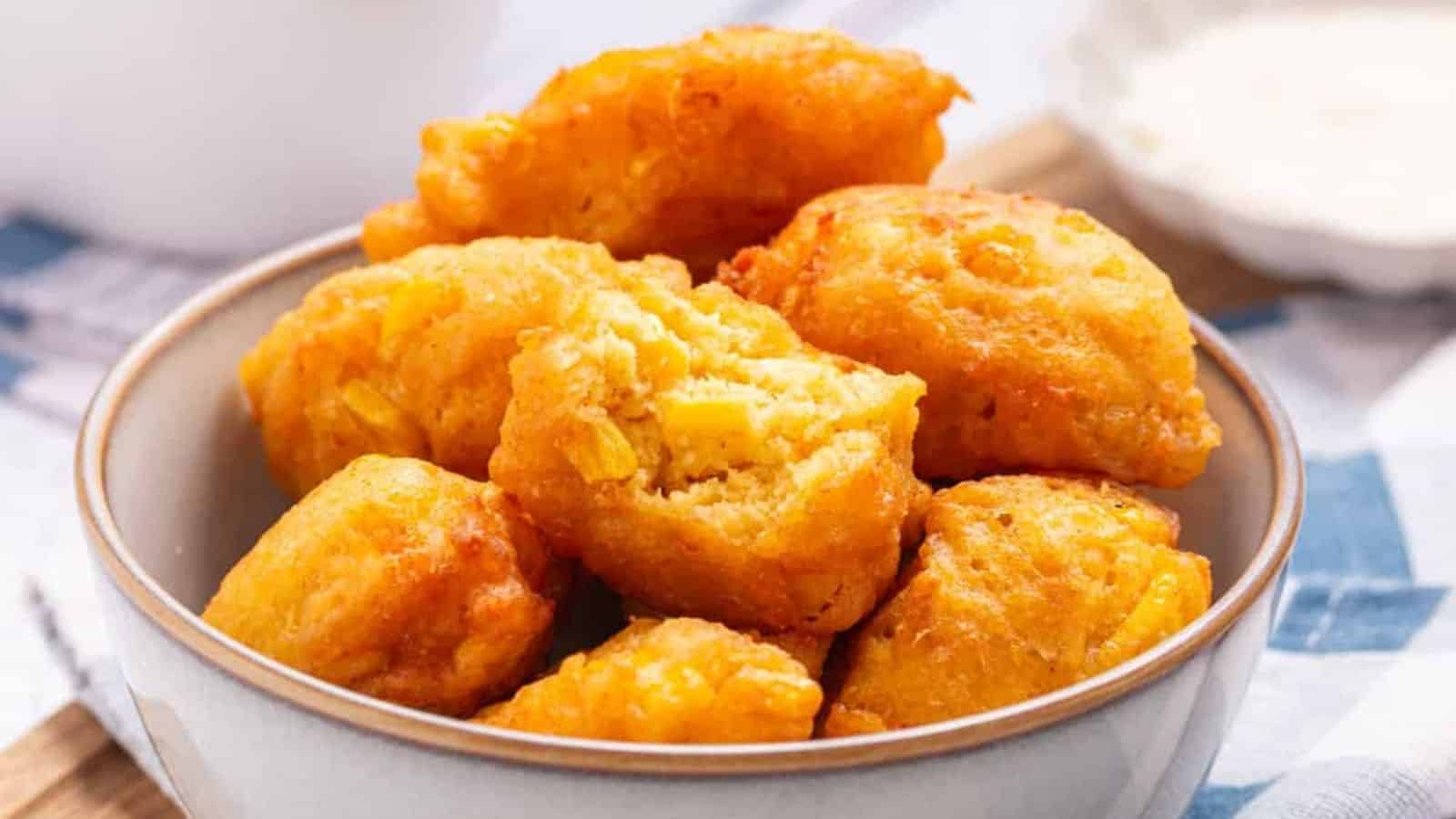 A bowl filled with golden, crispy corn nuggets.