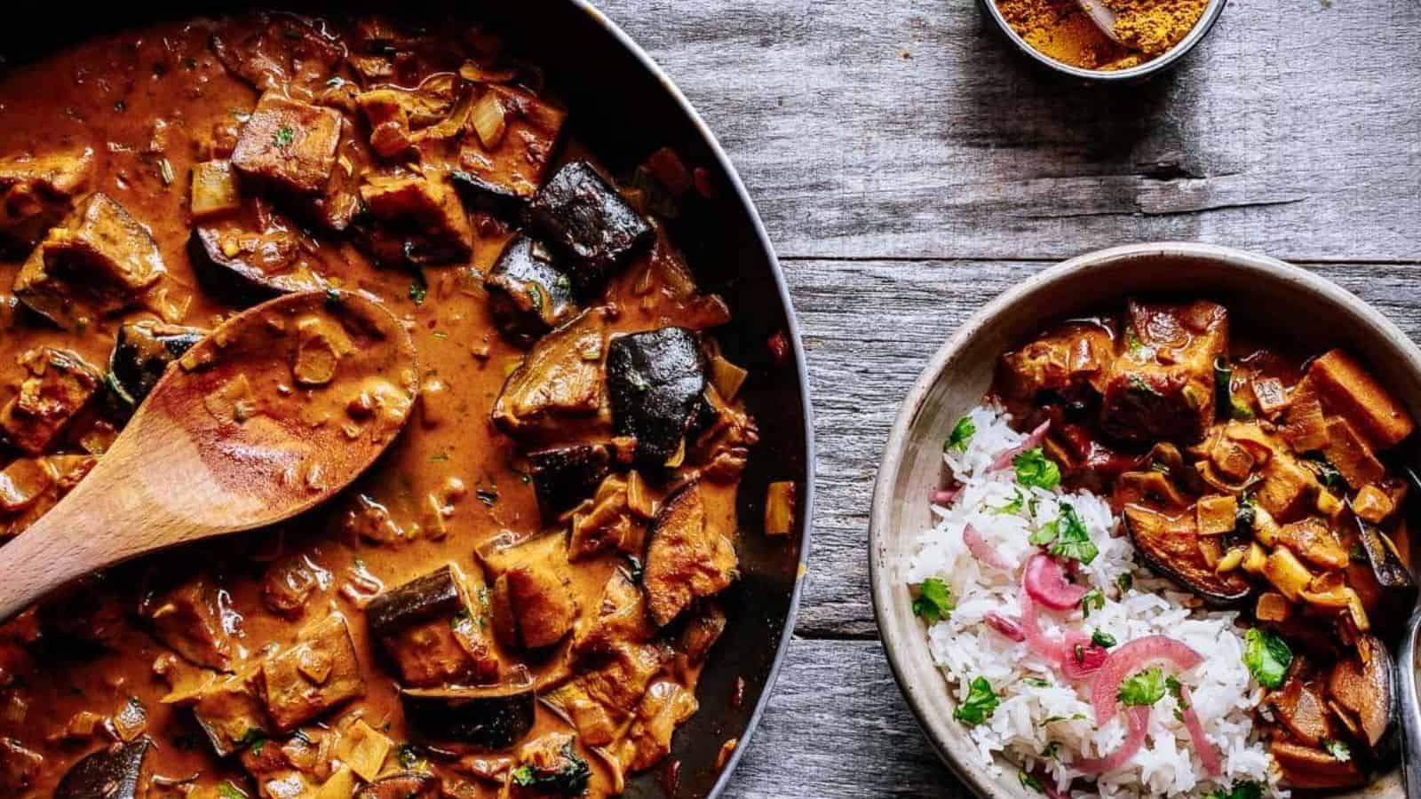 A vibrant and inviting bowl of creamy eggplant curry garnished with fresh cilantro on top.