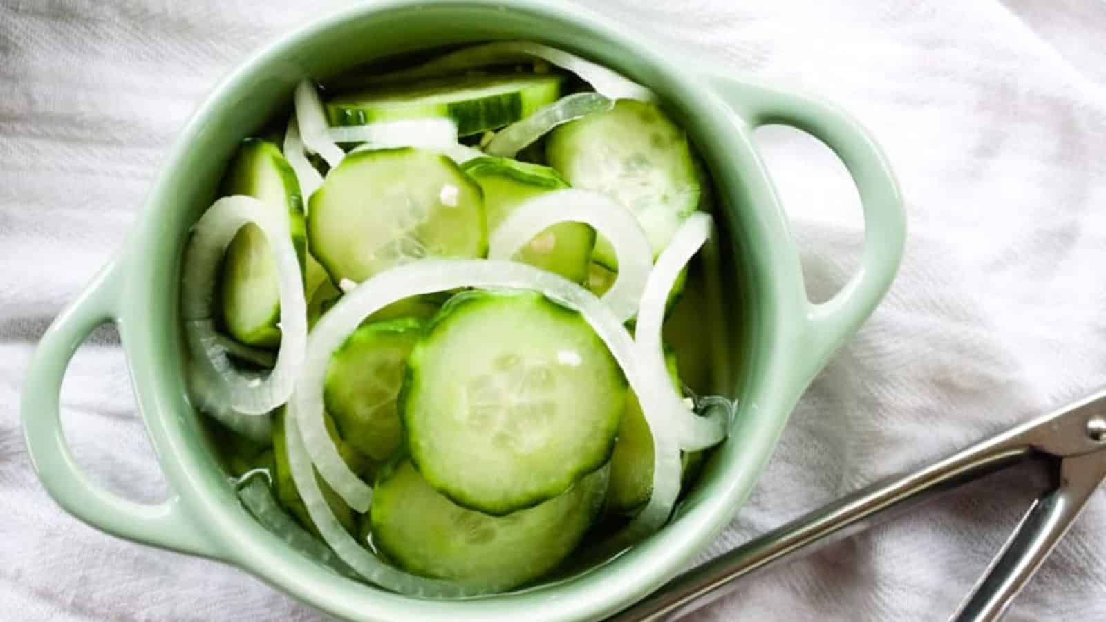 Top view of cucumber onion salad in a green bowl.