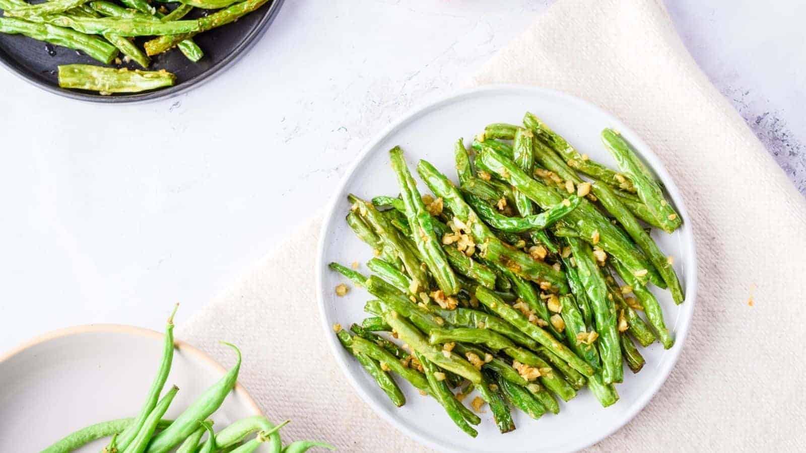 Overhead view of green beans placed on a paper towel on a platter.