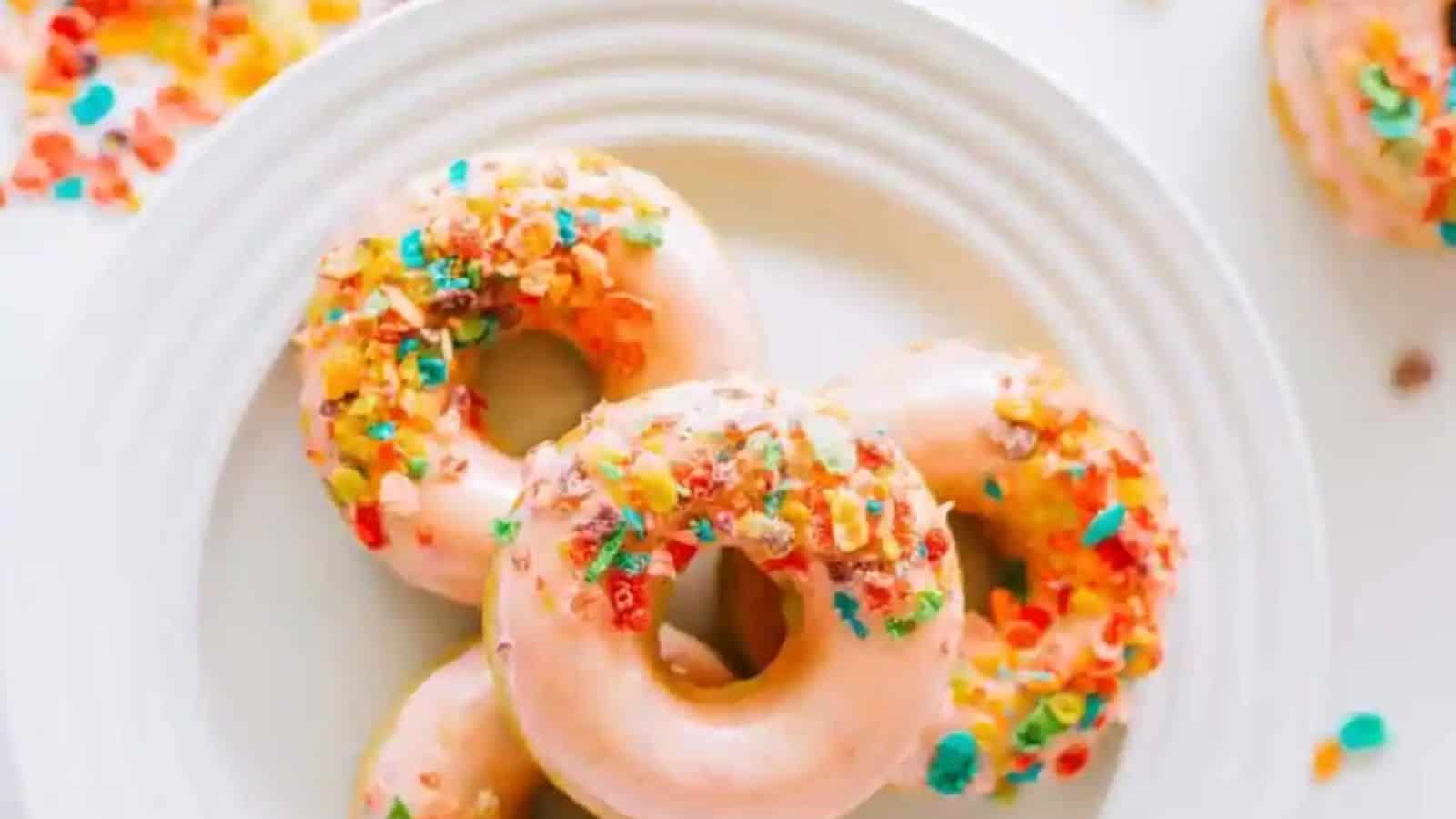 Top view of a stack of easy fruity pebbles donuts on a white plate.