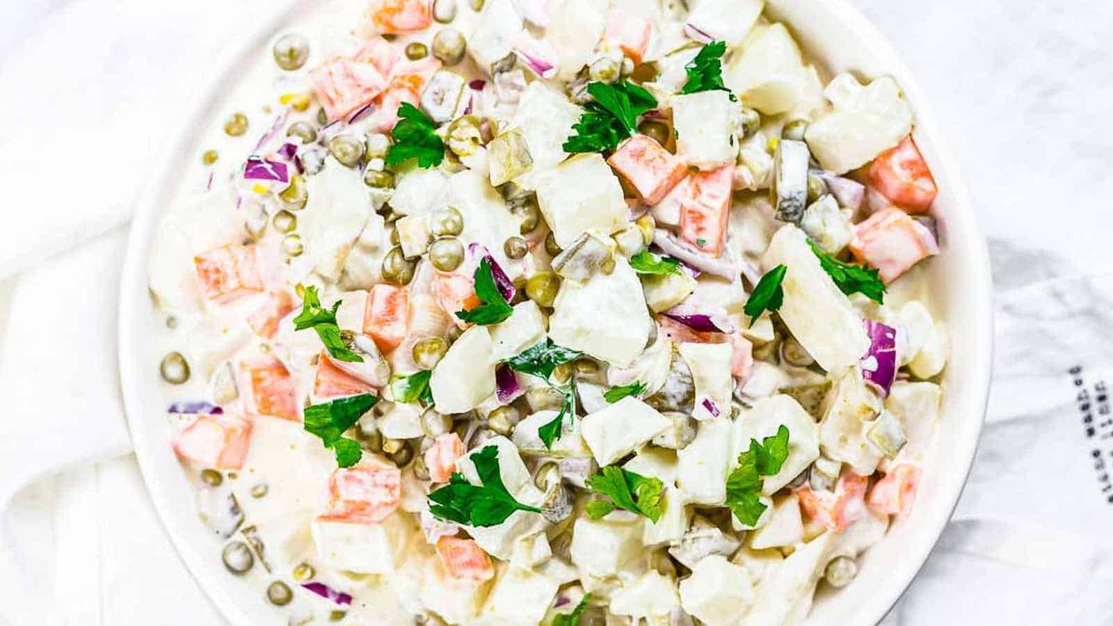 A white bowl of potato salad with mayonnaise.