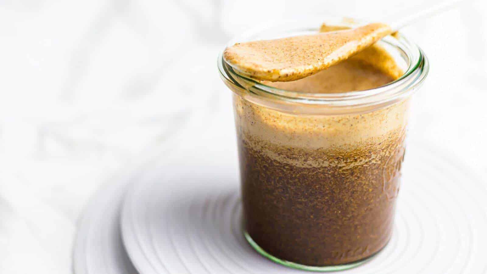 A jar of Worcestershire Sauce on a plate with a spoon.