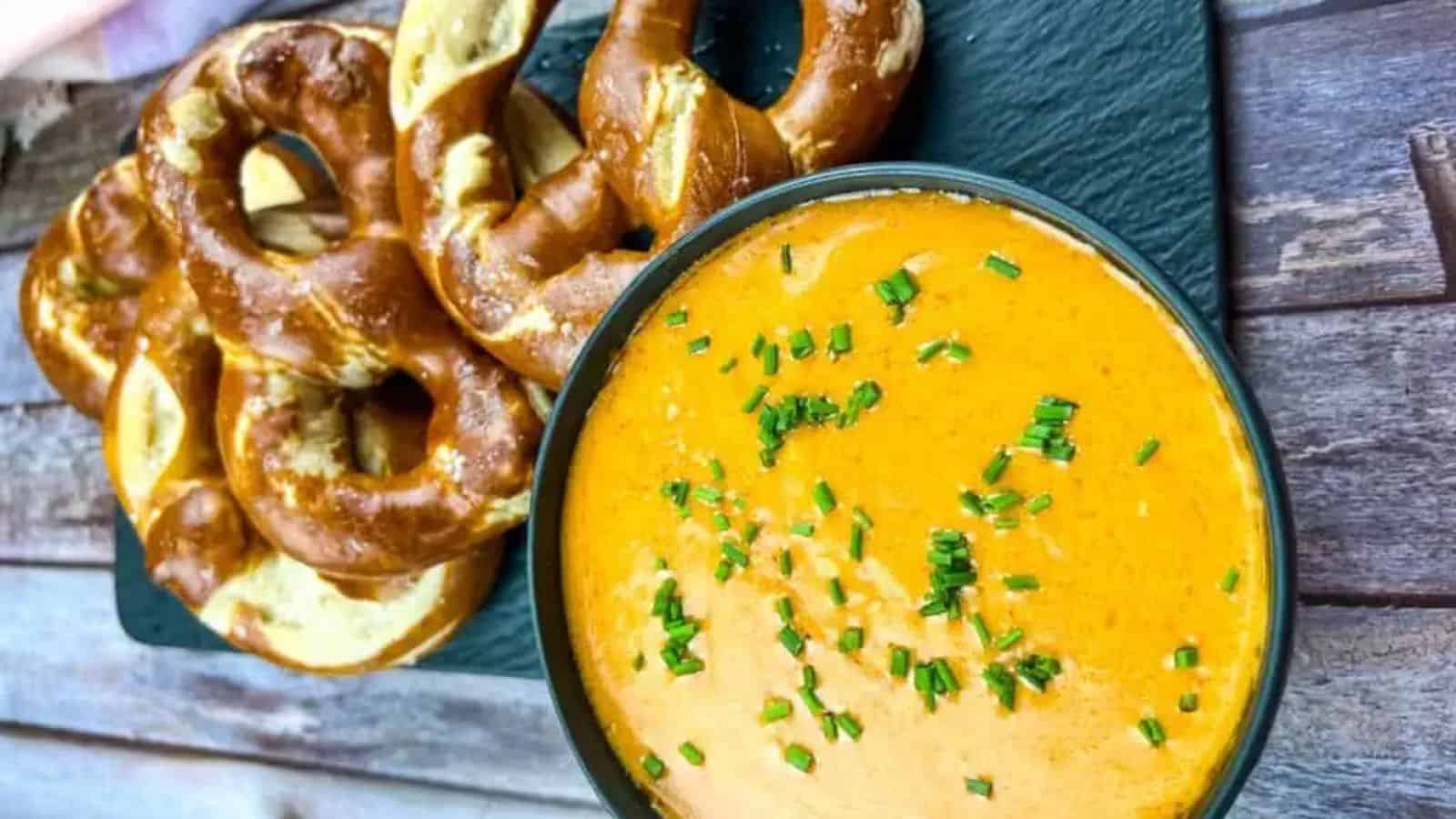 Overhead image of Guinness cheese dip in a bowl with a couple of pretzels in the background.