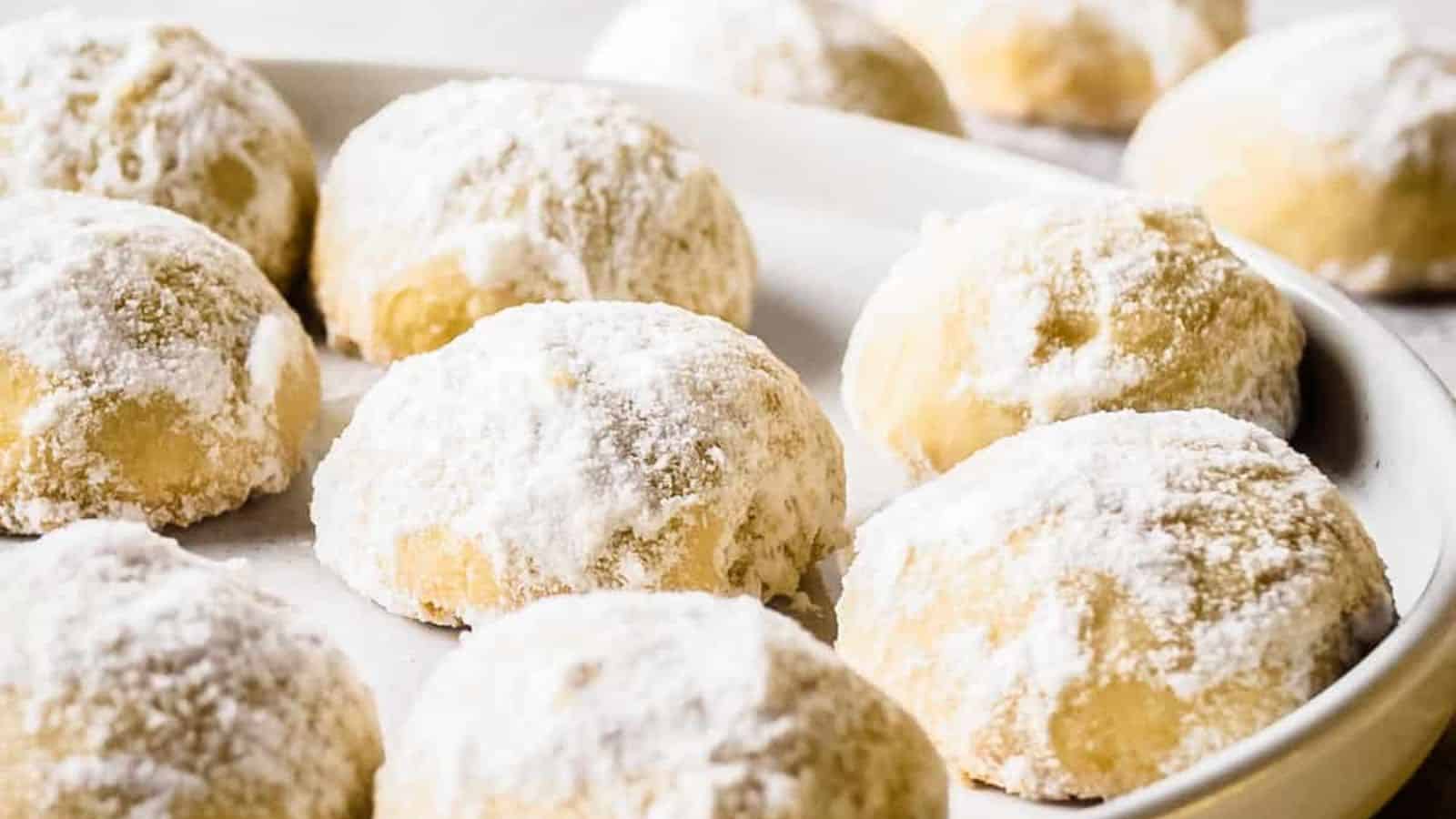 A close-up view of holiday butter cookies on a white plate.