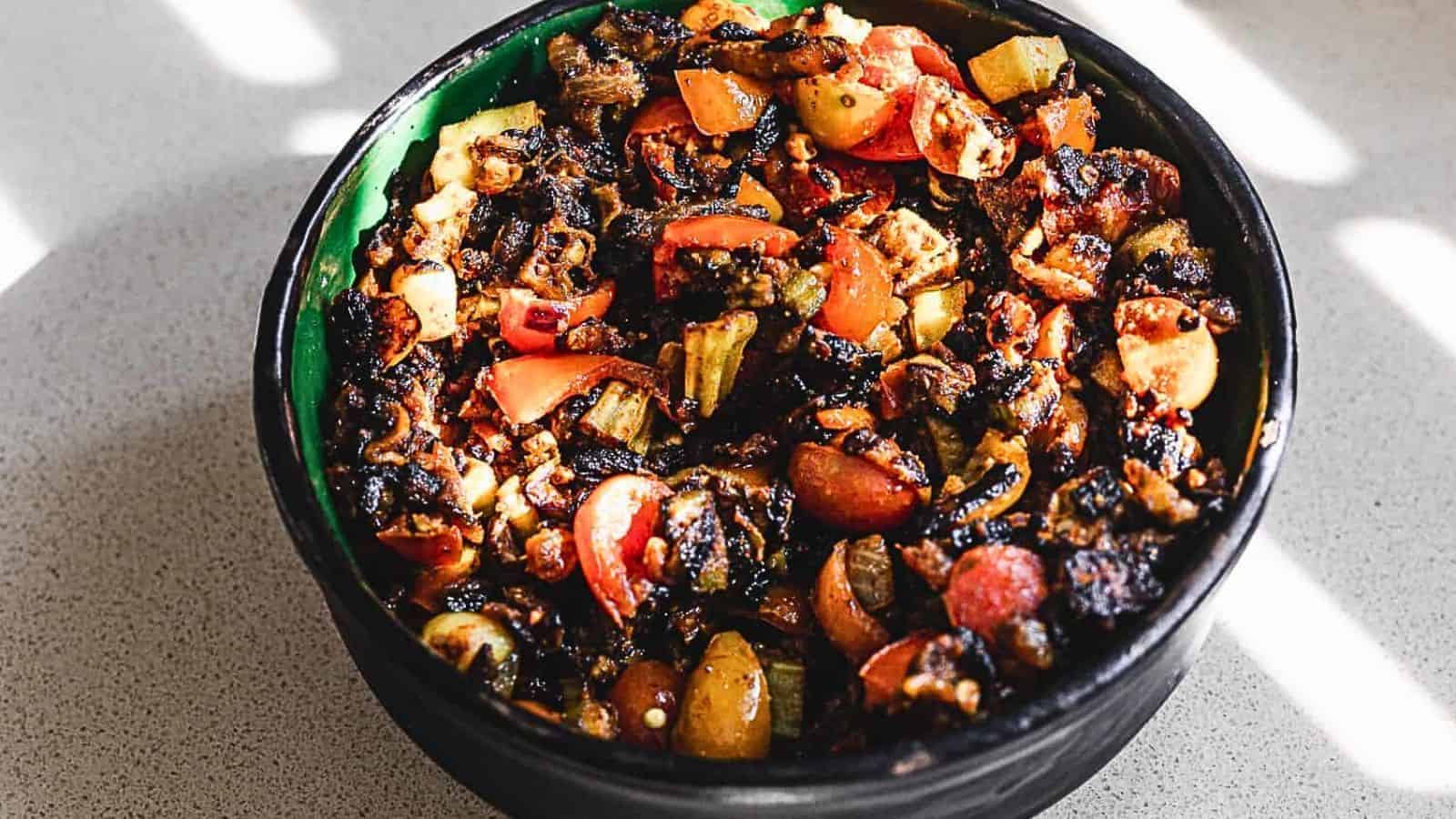 A black bowl filled with vegetables on a table.