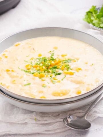 An image of instant pot corn chowder in a bowl with a spoon resting on the side.