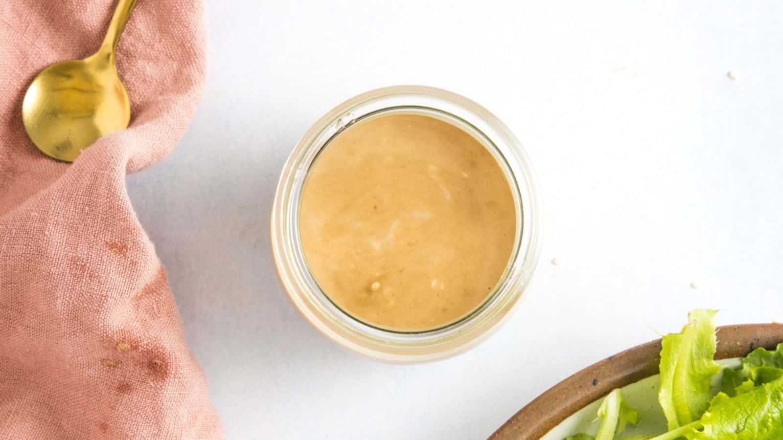 A top-down view of a jar filled with a creamy japanese sesame dressing.