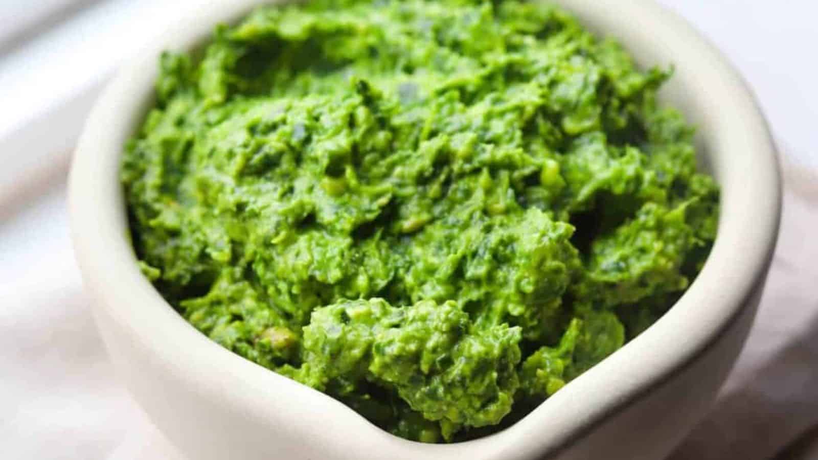 A close-up image of kale pesto sauce in a bowl.