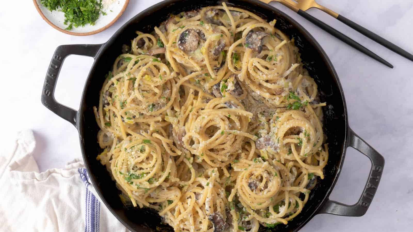 An overhead image of cooked leek mushroom pasta in a pan.