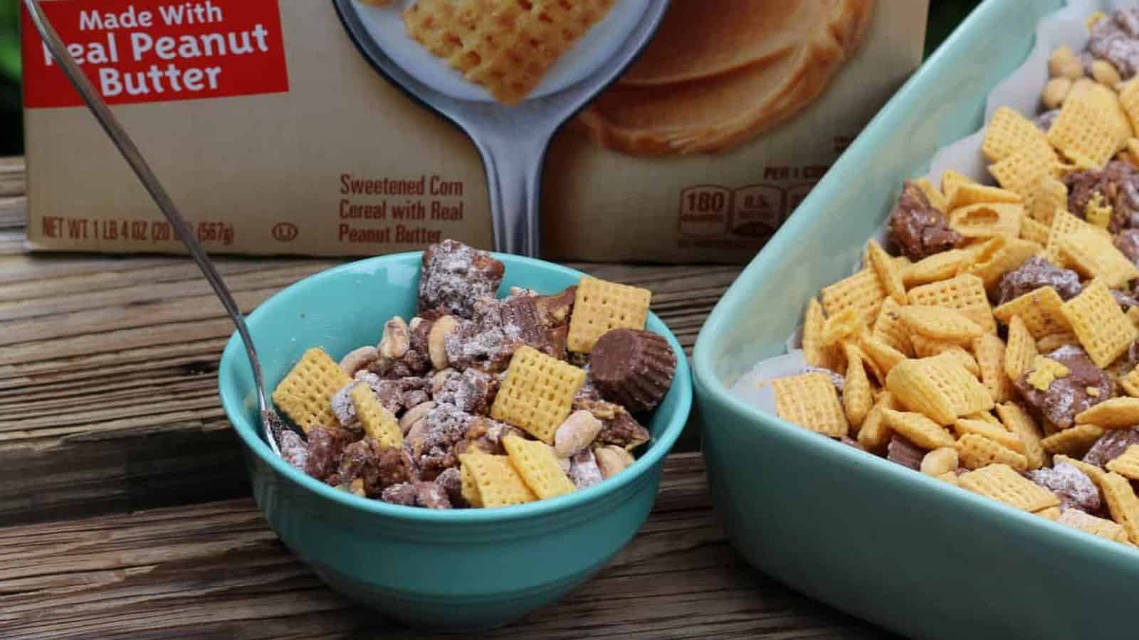 Teal bowl of chex party mix next to a cereal box and casserole dish.