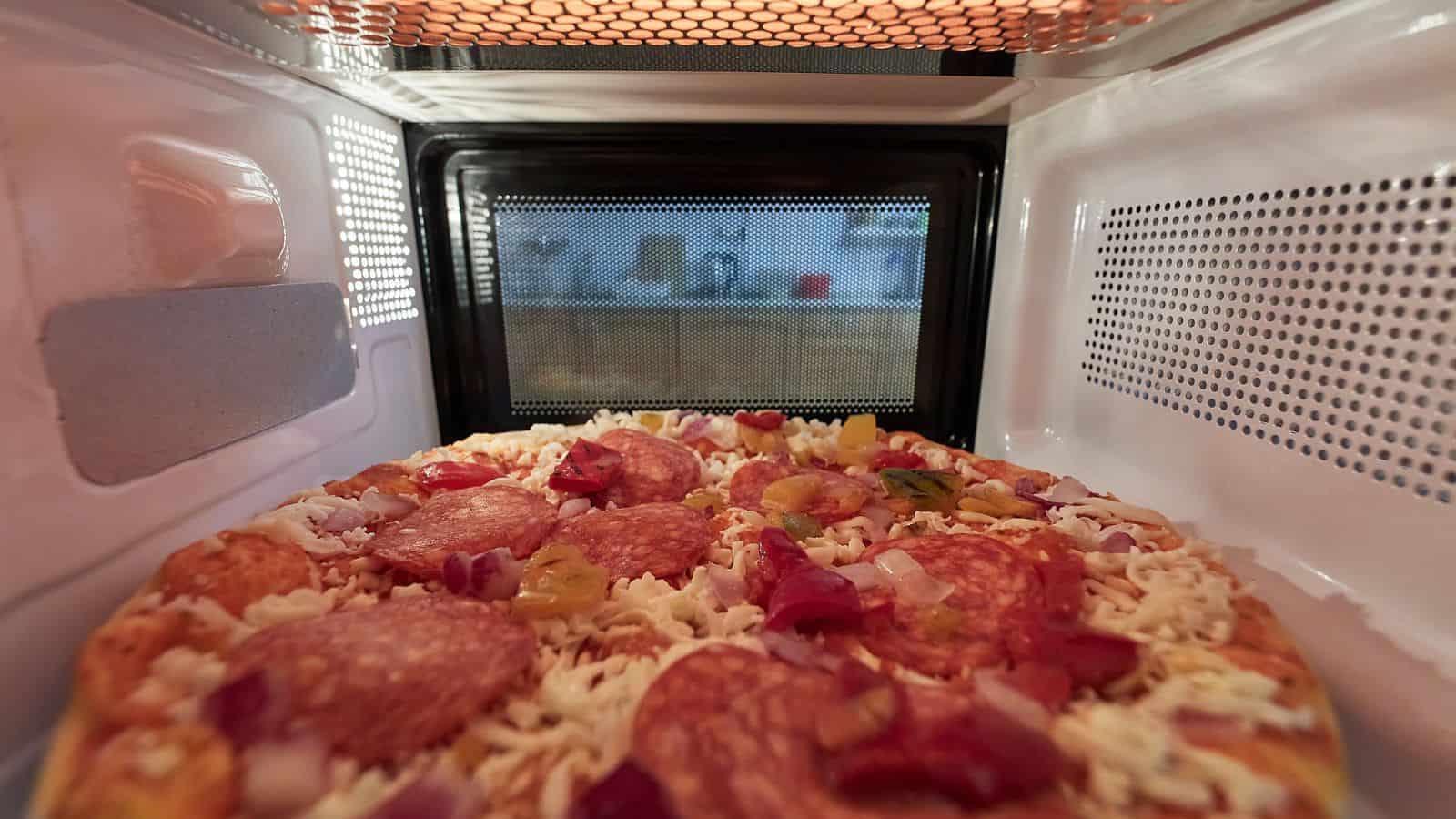 Heating pizza in a microwave oven.