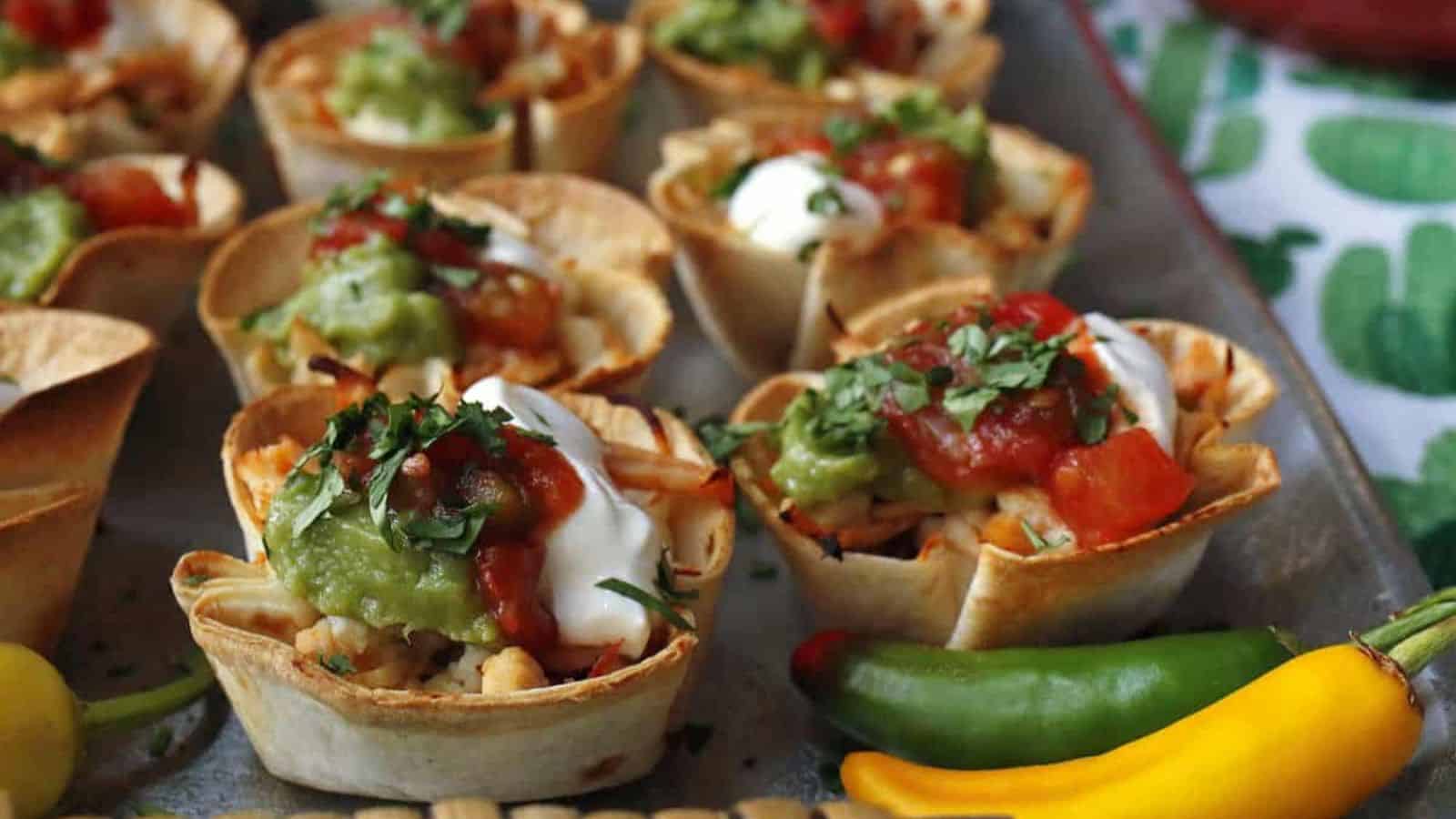 Mini chicken taco cups on a silver tray.