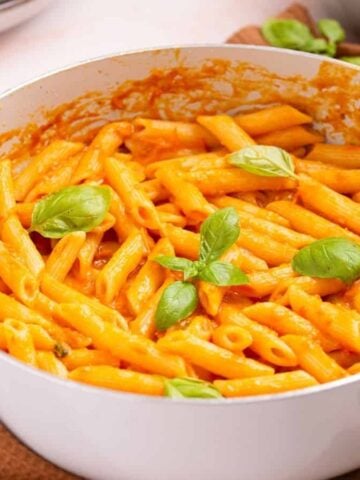 An close up photo of cooked penne pomodoro in a pot.