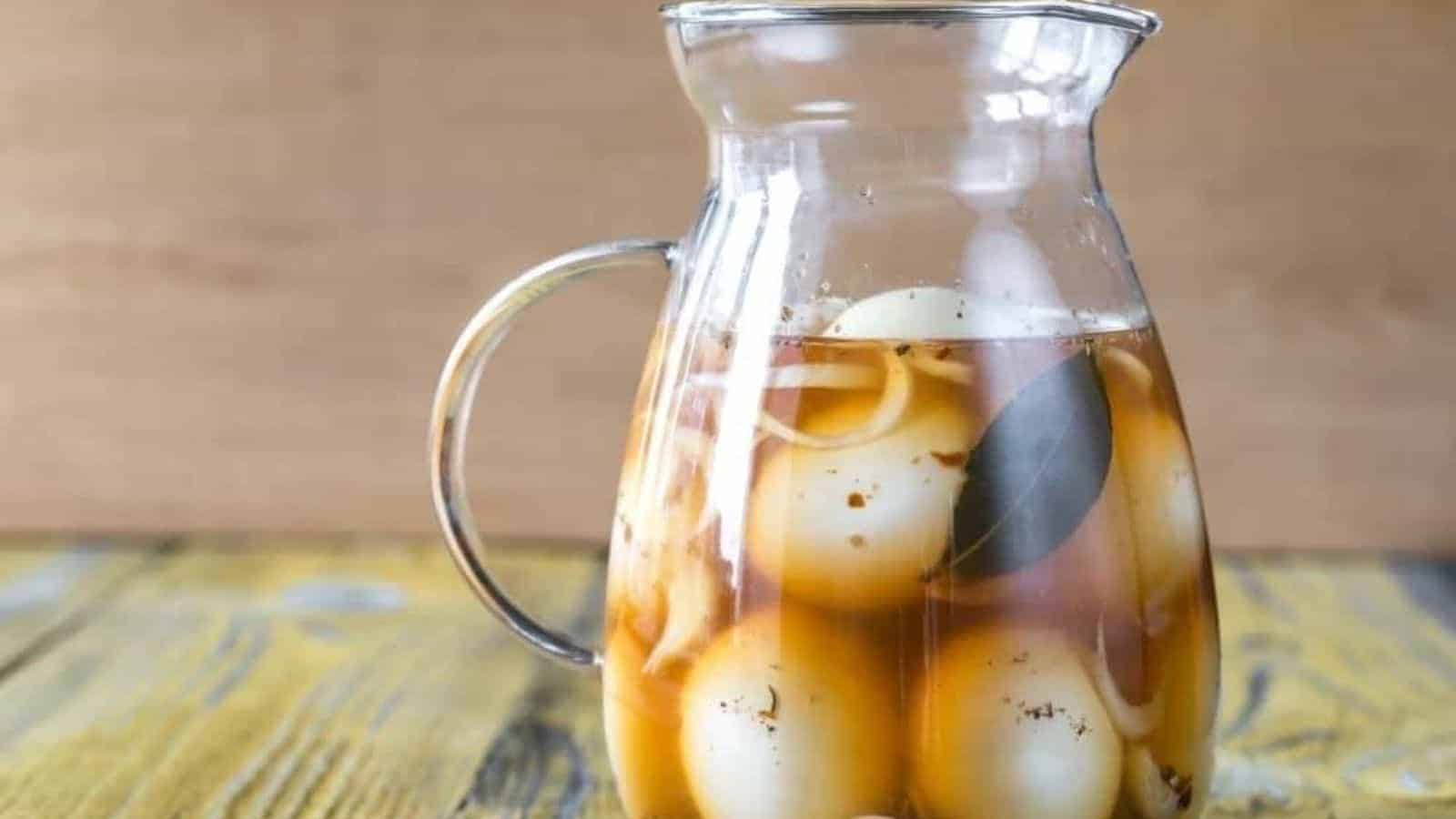 Pickled eggs in glass pitcher.