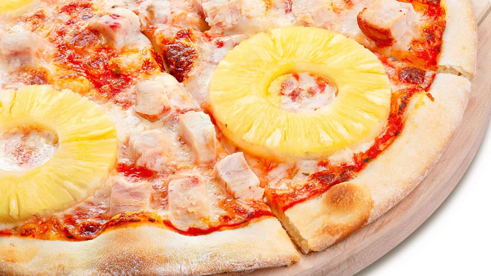 Close-up of pizza with pineapple slices on top.