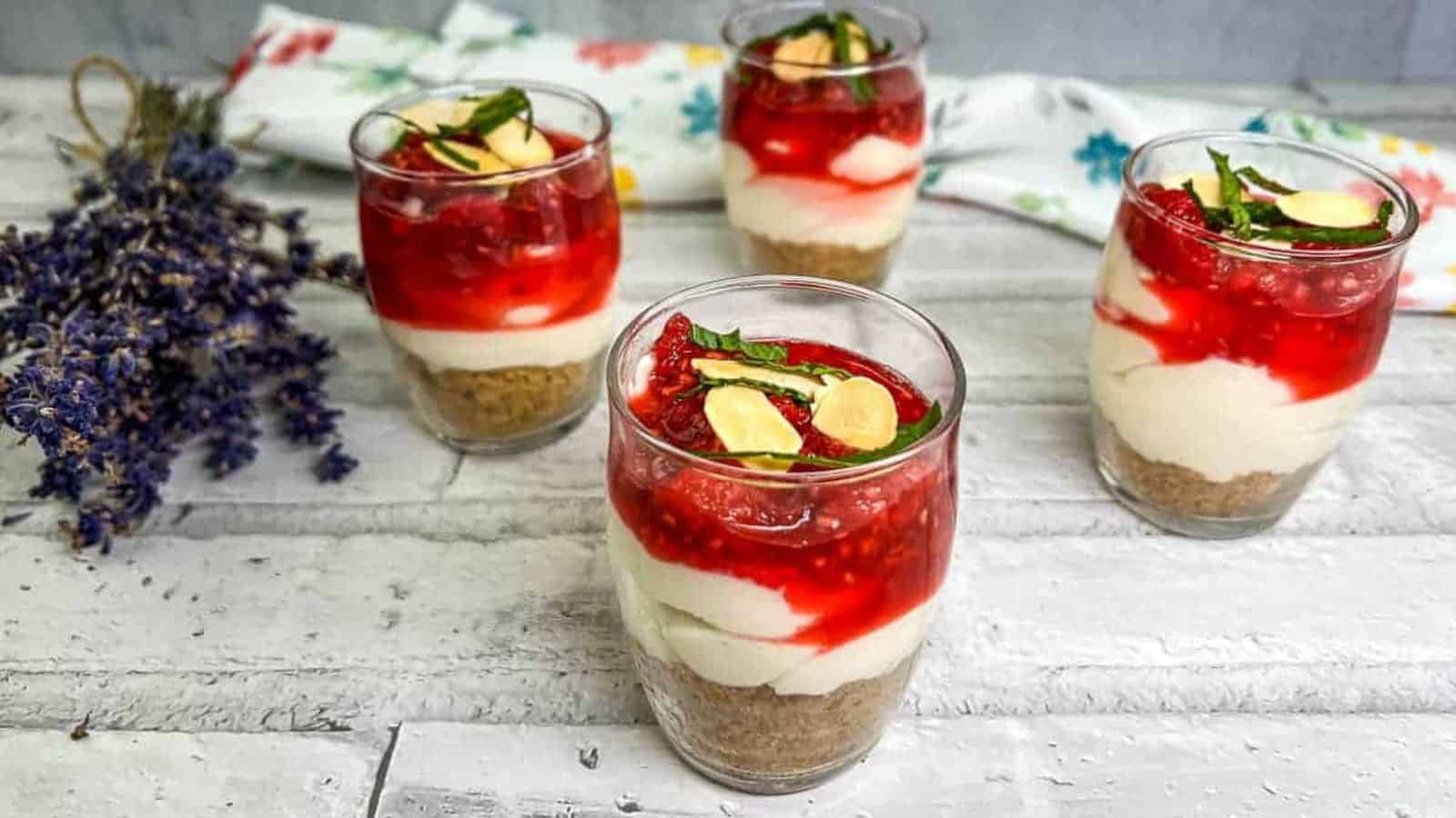 Four glasses of raspberry cheesecake parfait.