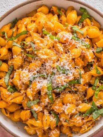 An overhead view of a cooked spicy vodka pasta in a white plate.