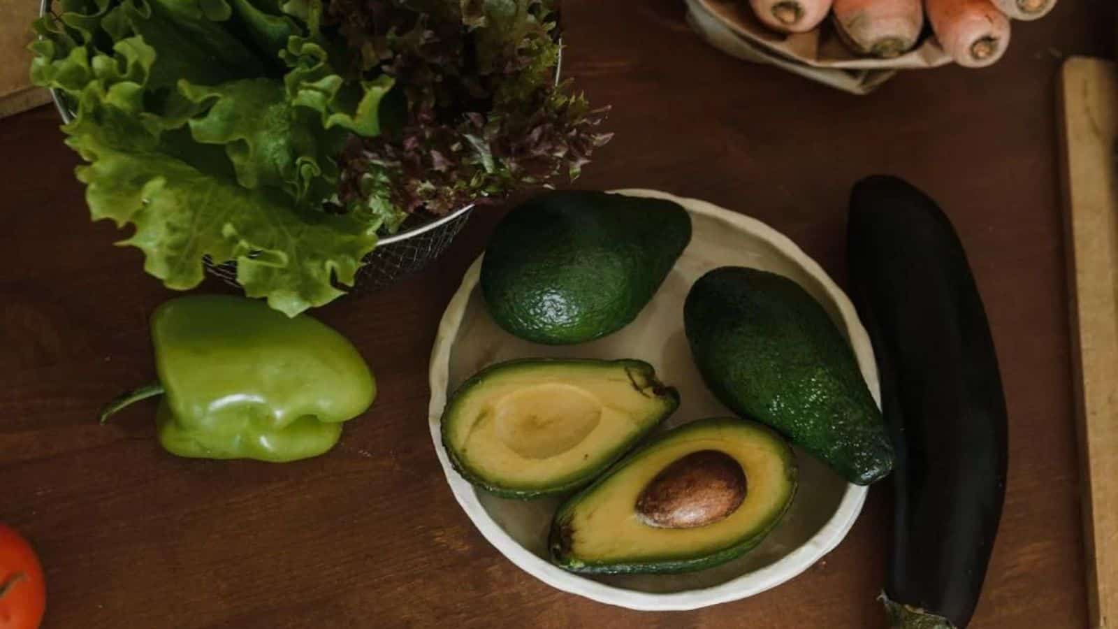 Close Up Photo of avocados in a plate accompanied by other vegetables.