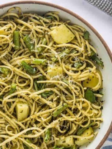 An overhead image of trenette al pesto in a round serving plate.