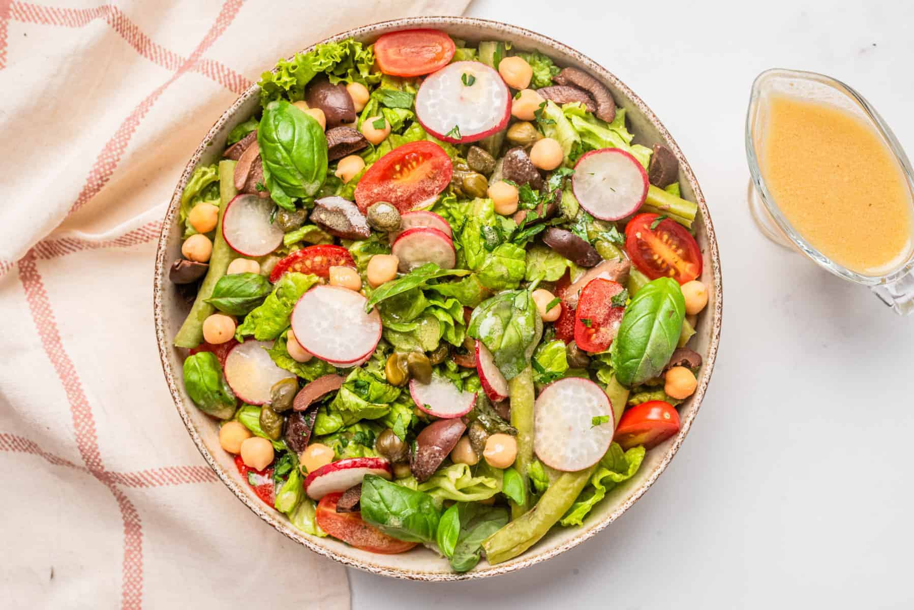 An image of vegan nicoise salad served on a big bowl.