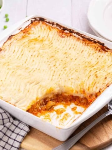 Close up view of vegan shepherd's pie in a white baking dish.