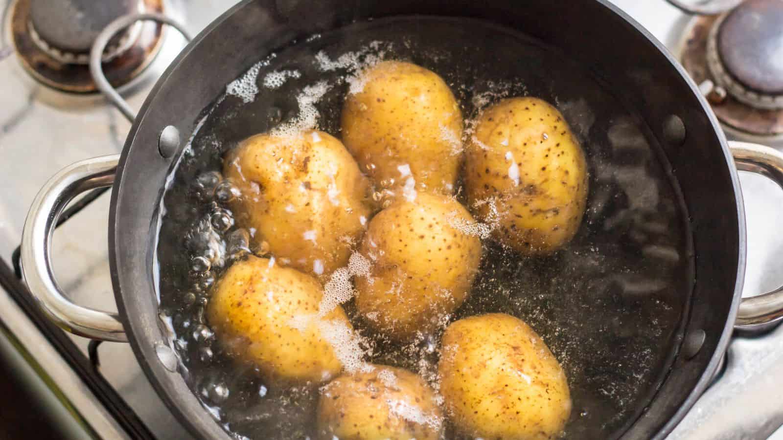 Potatoes that cook in a saucepan in selective focus.