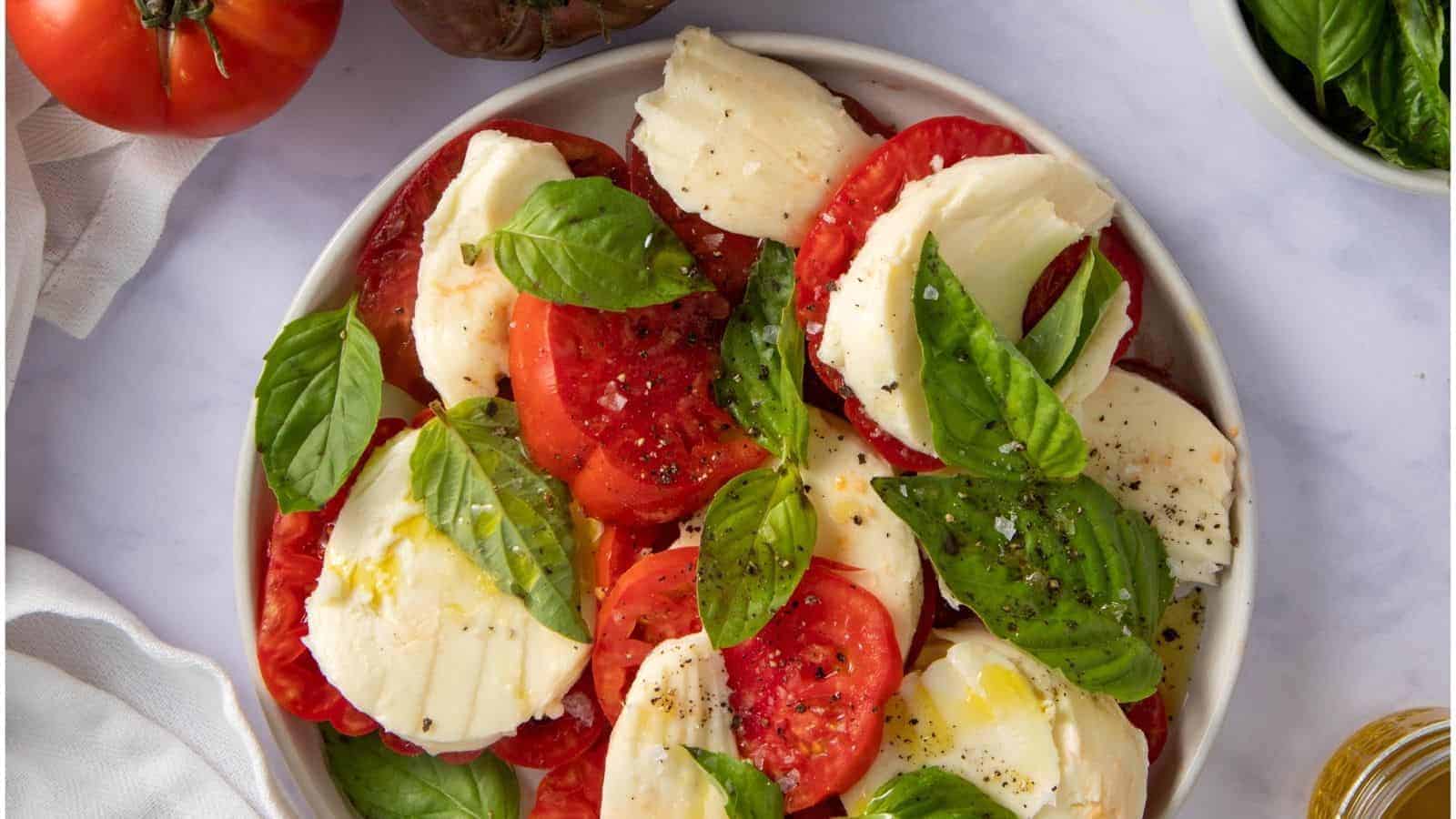 An overhead photo of caprese salad served in a white bowl.