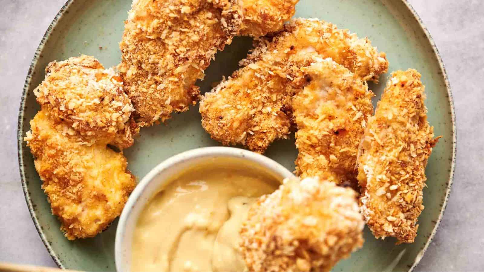 A plate of air fryer chicken tenders with a dip.