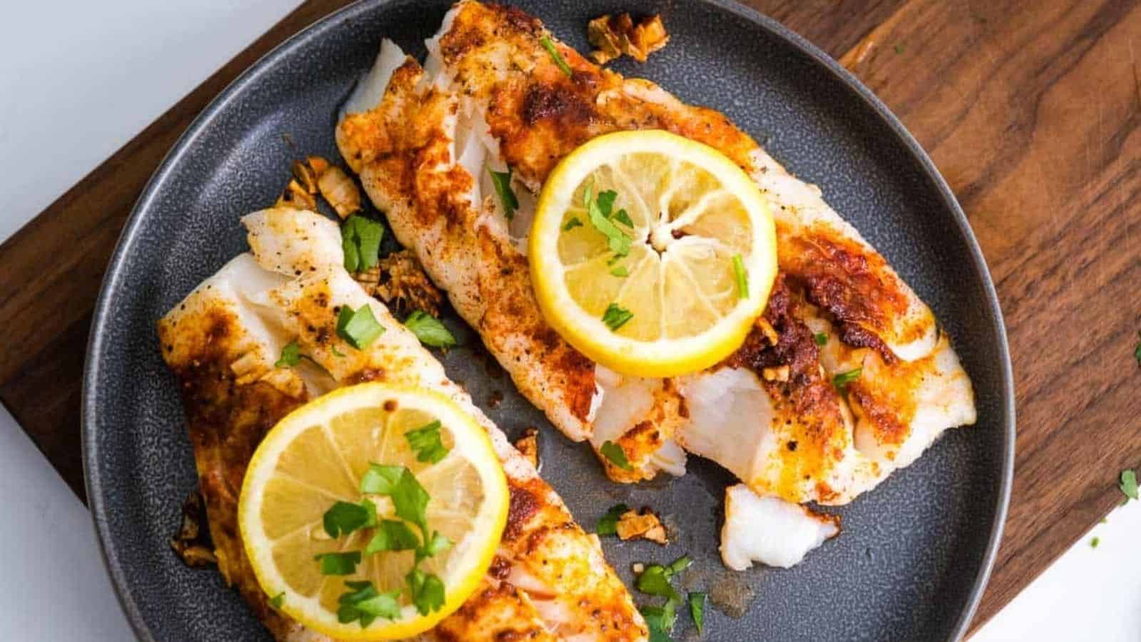 Air fryer cod fillets without breading topped with lemon and herbs.