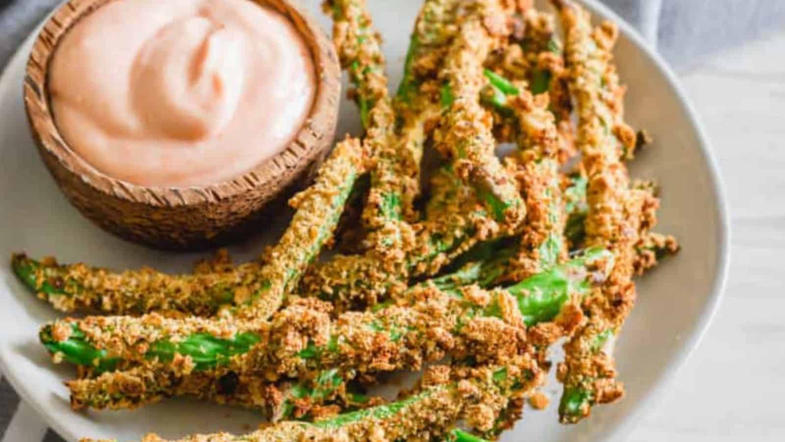 Close-up image of air fryer green bean fries in a white plate.