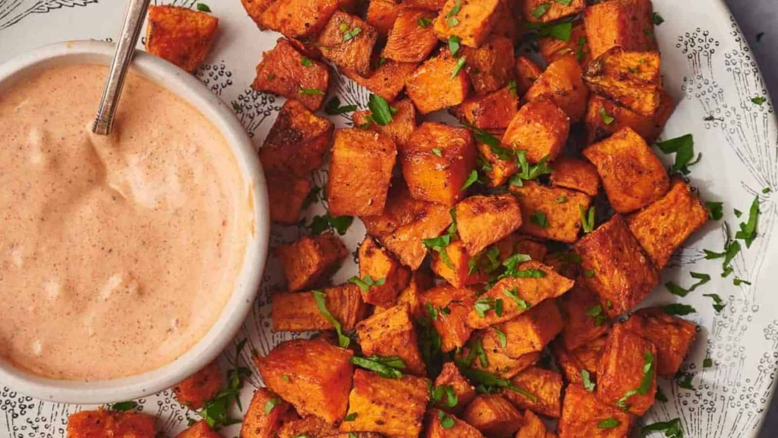 Sweet potato cubes on a plate with a dipping sauce.