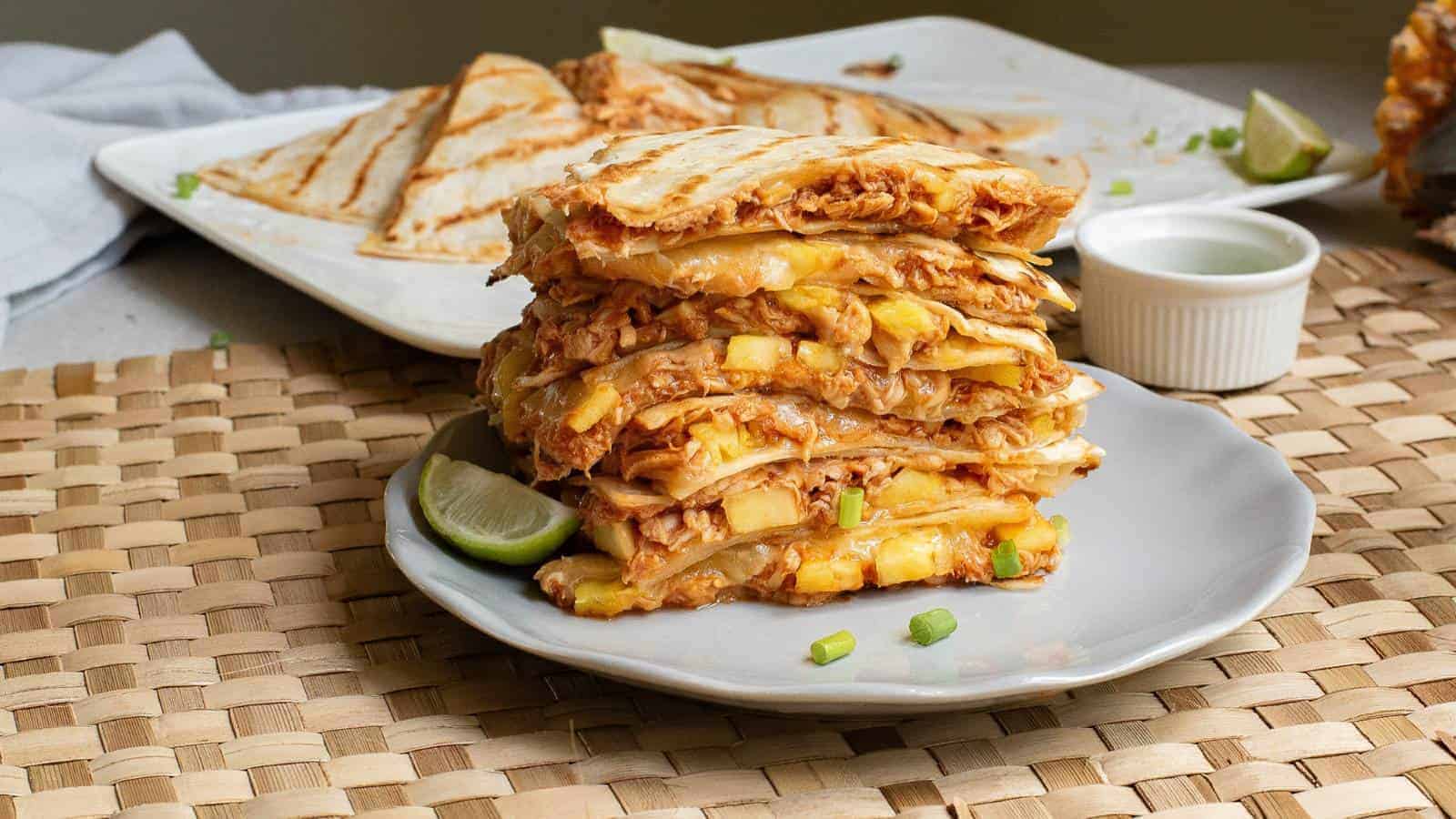 Quesadillas with cheese and chicken stacked on a plate.