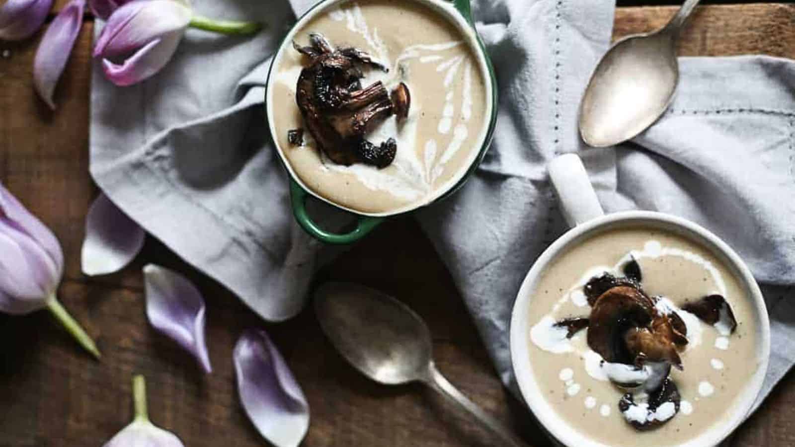 Two bowls of soup on a wooden table.