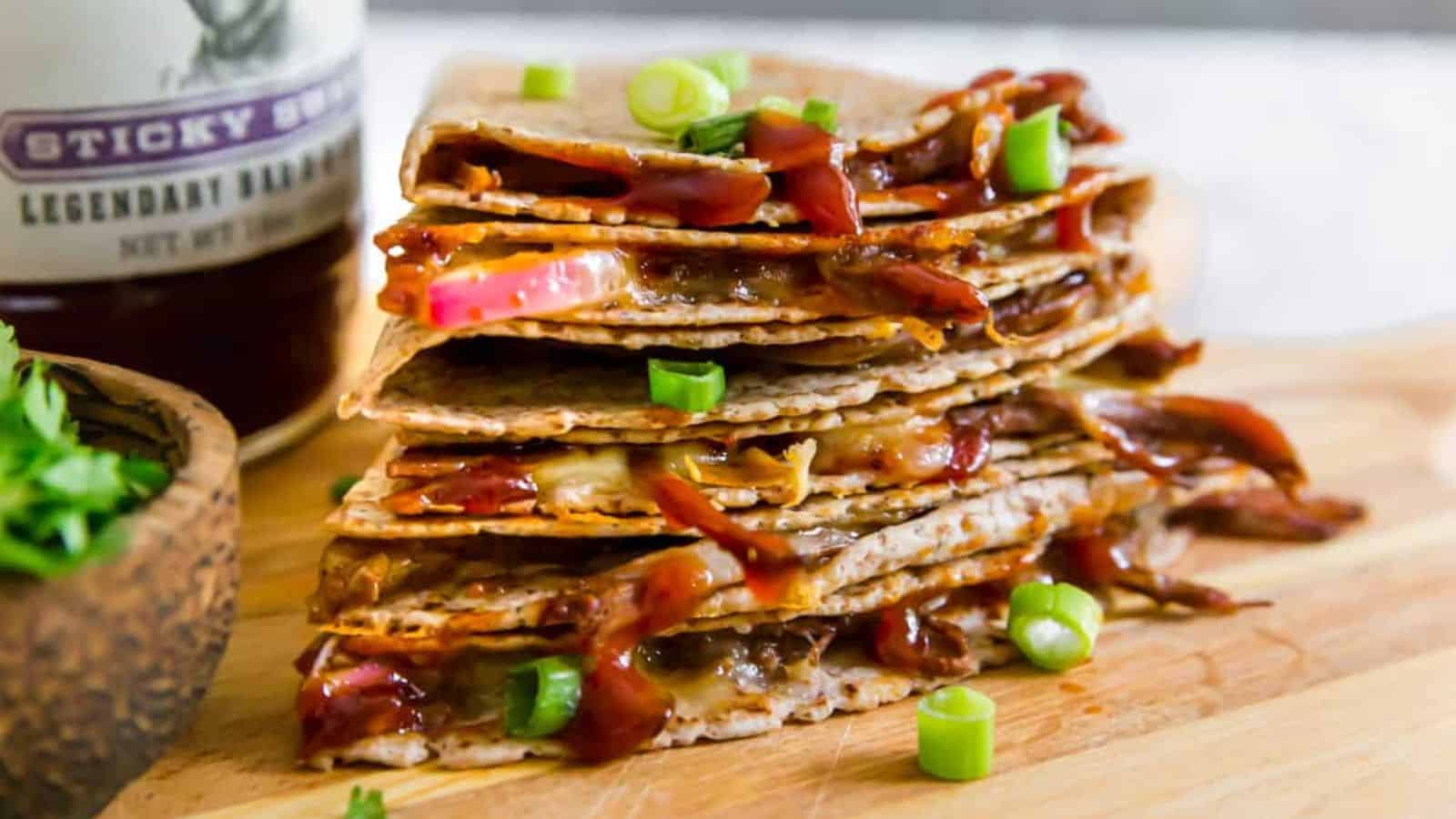 A stack of brisket quesadillas placed on a wooden board.