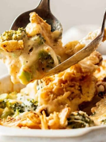 Someone serving broccoli casserole.