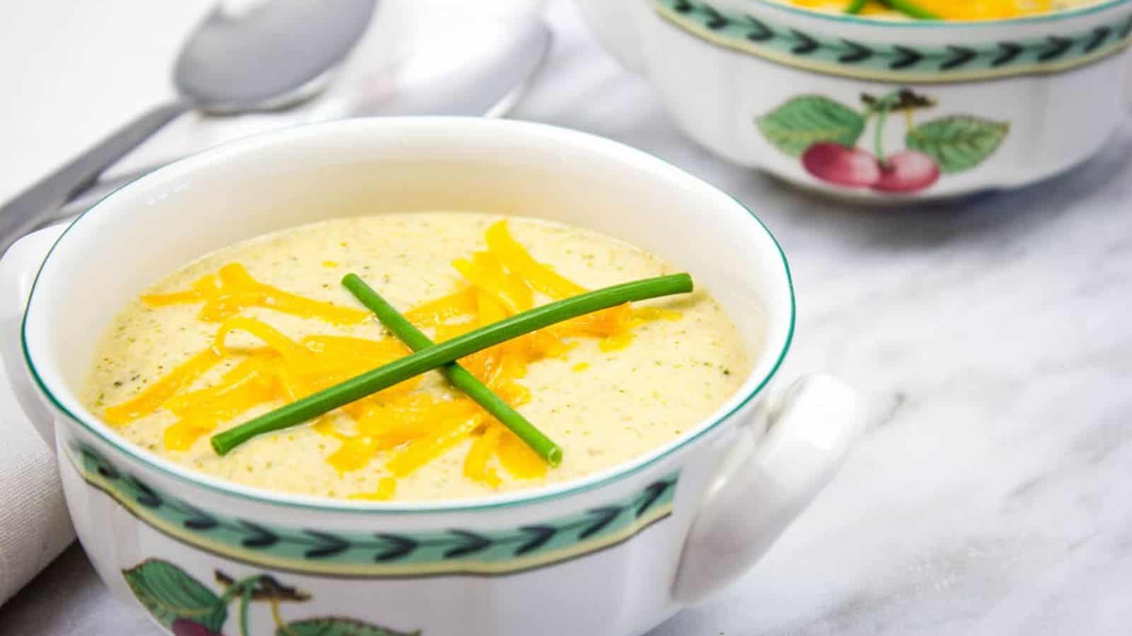 Broccoli Cheese Soup in two bowls with spoons nearby.