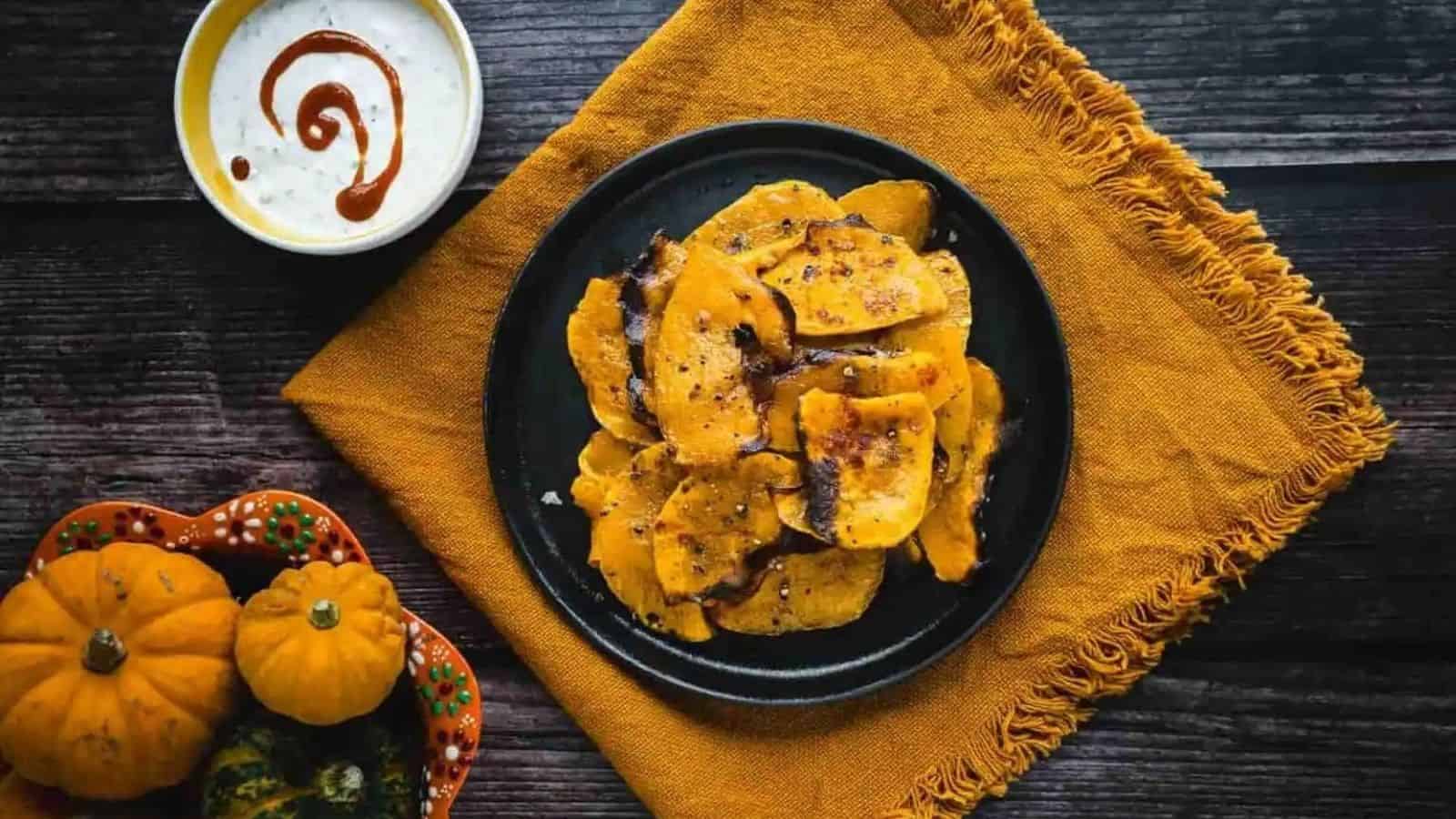 Top view of butternut squash chips in a black plate.