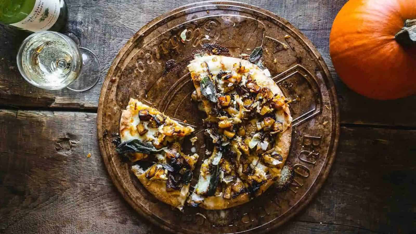 An image of caramelized onion and pumpkin pizza with fried sage.