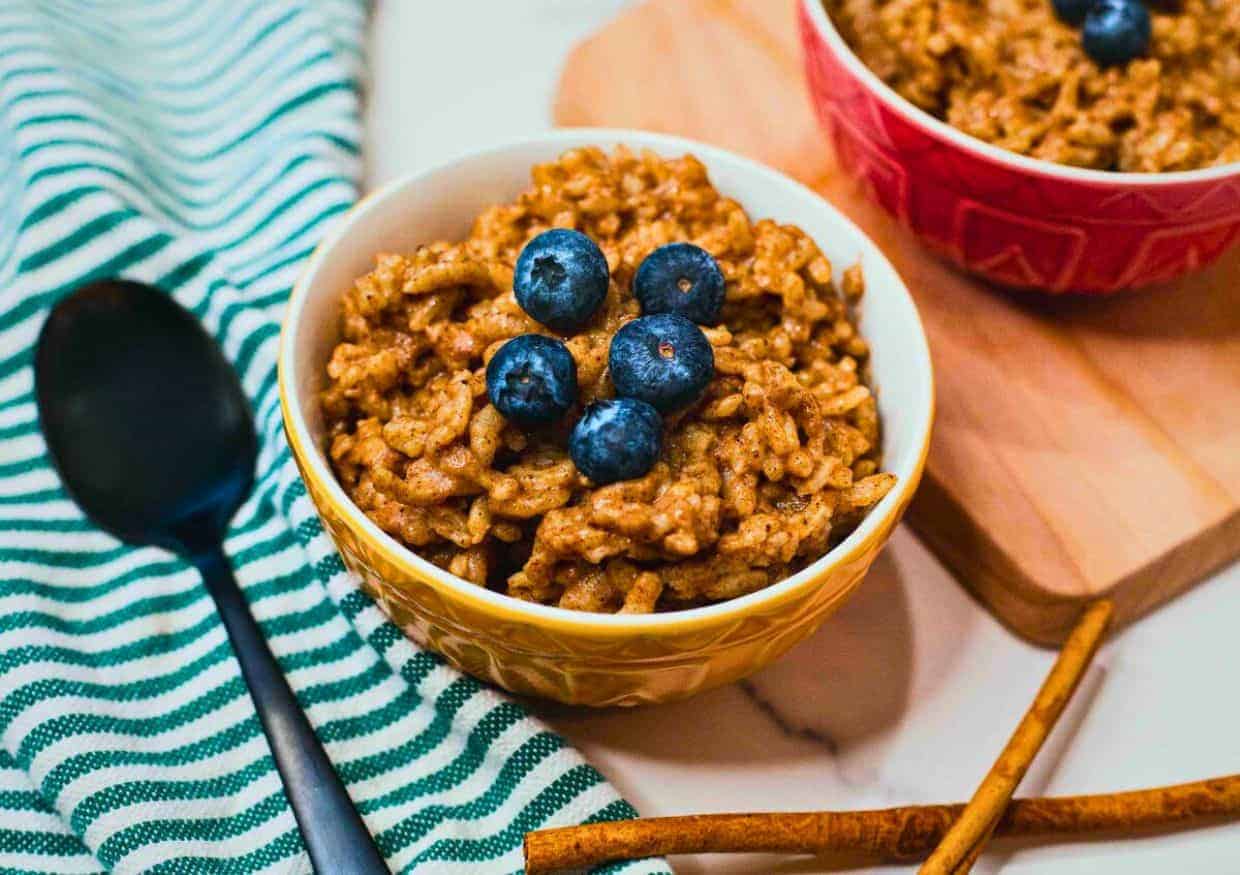 A bowl of creamy chai rice pudding topped with fresh blueberries.