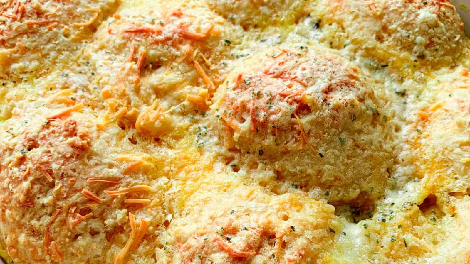 Sausage and gravy biscuit casserole in a baking dish and a serving bowl with the same and white gravy.